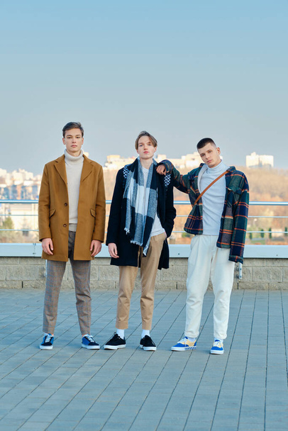 Three young men in casual clothes posing on the street - Zdjęcie, obraz