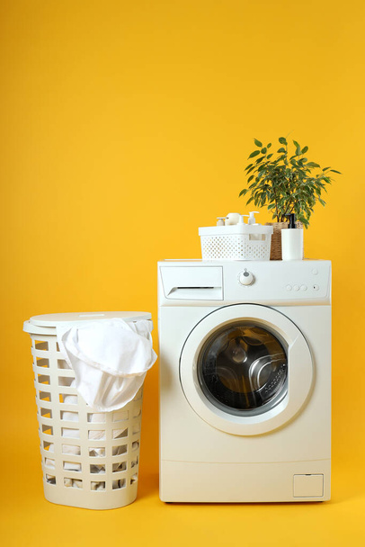 Concept of housework with washing machine on yellow background - Photo, Image