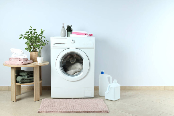 Концепция работы по дому со стиральной машиной против белой стены - Фото, изображение