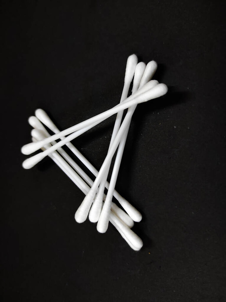 photo of several sticks of cotton buds isolated on black background - Photo, Image