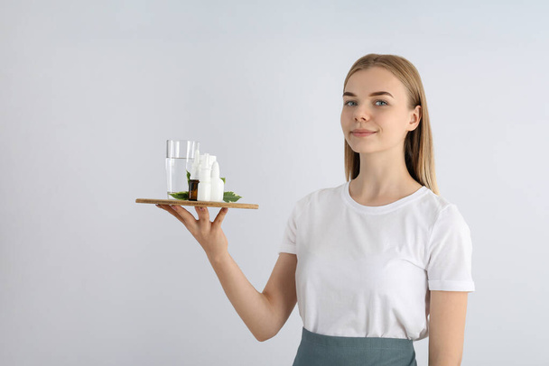 Young woman waiter holds tray with medicines - Foto, Imagen