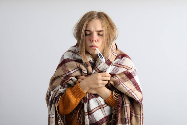 Chorą młodą kobietę na jasnym tle, koncepcja sezonowego zimna - Zdjęcie, obraz