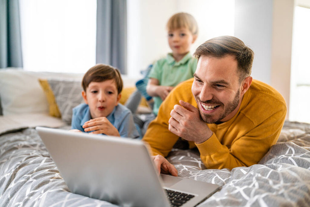 Happy cute family at home looking at laptop and having fun - Φωτογραφία, εικόνα