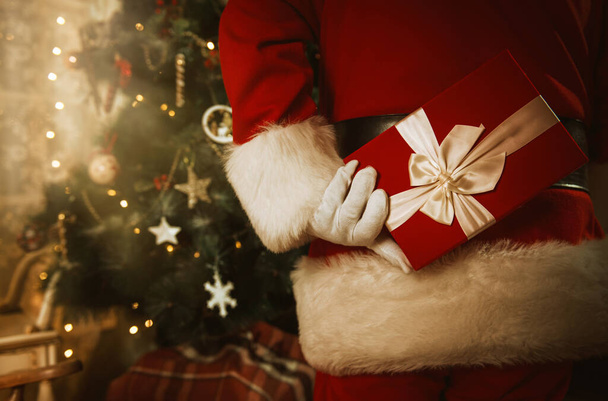 Санта Клаус тримає подарунок за спиною.  - Фото, зображення