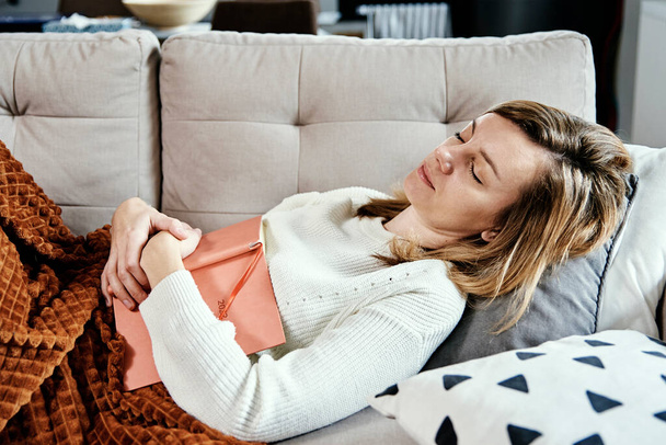 Mujer duerme en sofá con libro - Foto, imagen