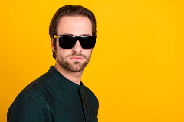 Photo of confident cool young guy dressed smart casual clothes dark eyewear empty space isolated yellow color background - Fotó, kép