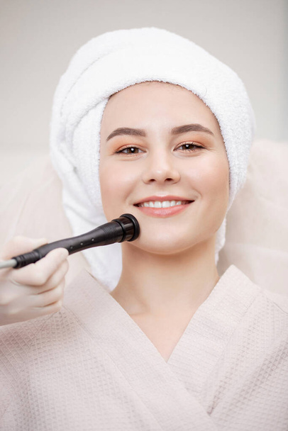 Procedimento de close-up microcurrent para levantamento de pele tratamento facial jovem mulher da clínica de spa - Foto, Imagem