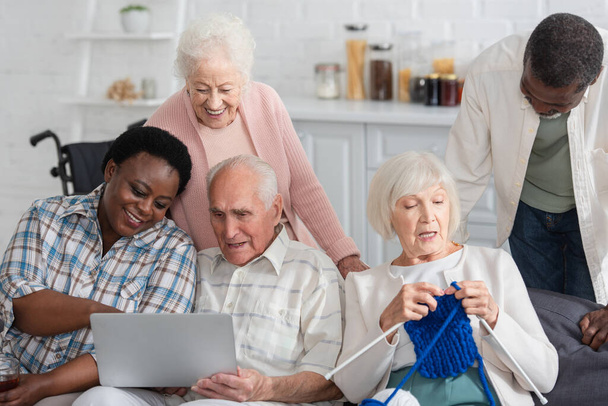 Les retraités interracial seniors passent du temps avec du fil et un ordinateur portable dans une maison de retraite  - Photo, image