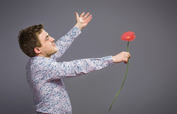 Portrait of man holding red flower  - Foto, Imagen