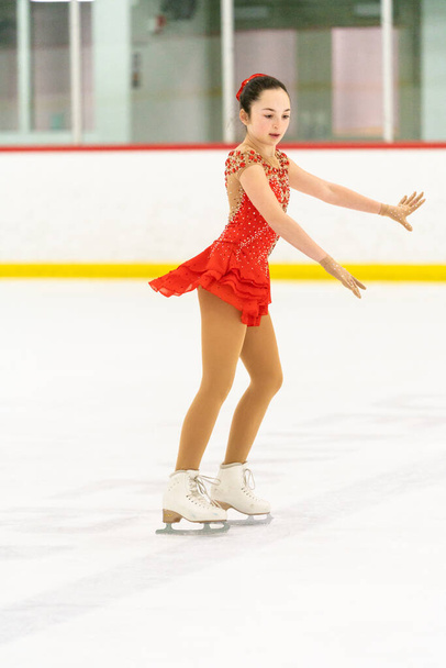 Teenage girl practicing figure skating on an indoor ice skating rink. - 写真・画像