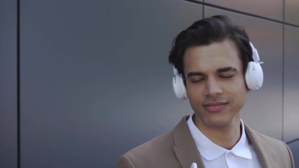 hombre satisfecho en auriculares inalámbricos disfrutando de la música  - Metraje, vídeo