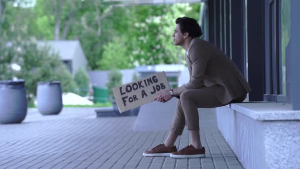 homem demitido segurando caixa com procurando um emprego lettering fora - Filmagem, Vídeo