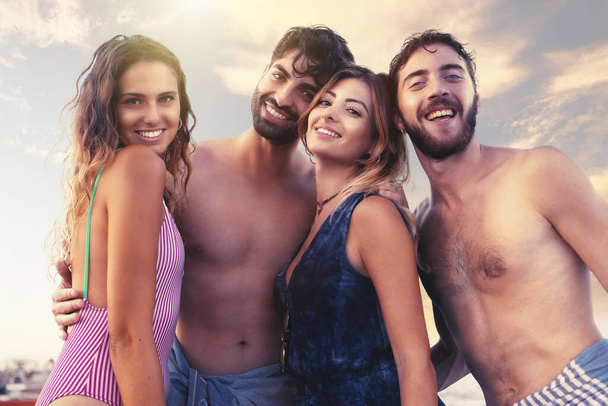 Portret młodych ludzi w strojach kąpielowych uśmiechniętych na plaży. Młodzież dobrze się bawiąca na wakacjach. - Zdjęcie, obraz
