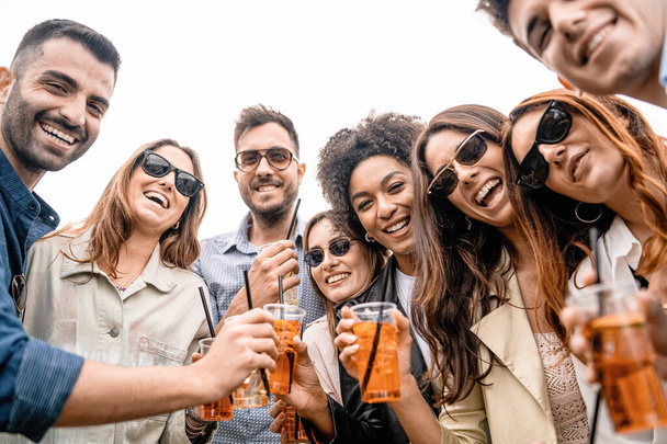 Велика міжрасова група молодих друзів на відкритому повітрі портрет Група молодих людей, які посміхаються, дивлячись на коктейлі для пиття камер у пластикових окулярах
 - Фото, зображення
