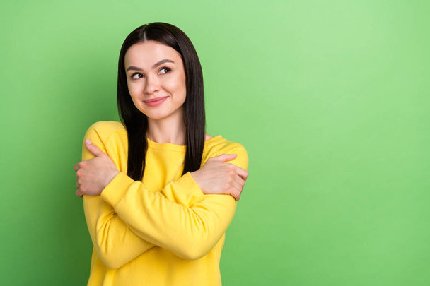 Photo portrait of young woman in yellow clothes embracing herself looking copyspace isolated on vivid green color background - Фото, зображення