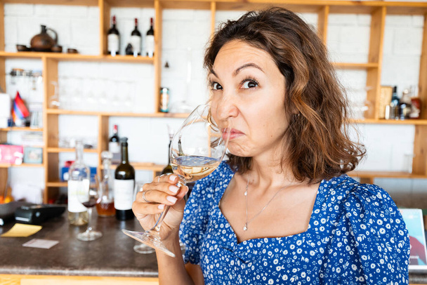 Woman sniffs and tasting bad wine. The concept of loss of sense of smell and long covid - Photo, Image