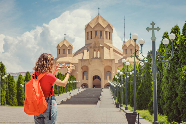 Donna felice scattare foto sul suo smartphone di un paesaggio urbano panoramico nella città di Erevan con vista sulla famosa Cattedrale di San Gregorio Illuminatore - Foto, immagini