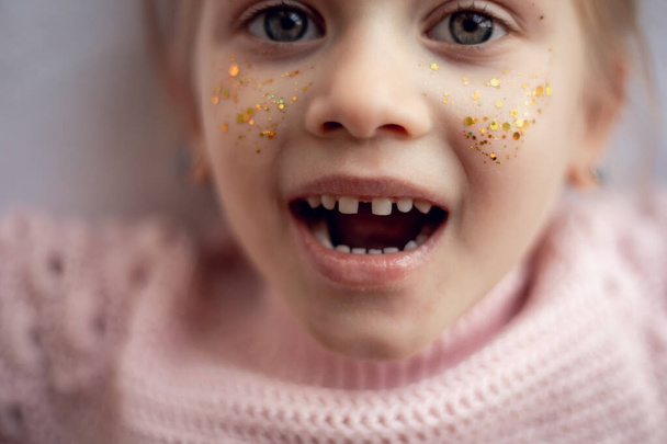 歯医者のオフィスで小さなブロンドの幸せな子供の女の子は笑顔を見せますめまい歯が欠落してギャップをオーバーバイト.歯列矯正医の訪問や口腔検査中の子供.子供の歯のケアと衛生 - 写真・画像
