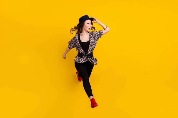 Full length photo of charming young happy woman look empty space run jump isolated on yellow color background - Foto, Imagen
