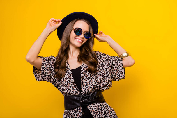 Photo of attractive happy nice young woman wear hat cool sunglass leopard blouse isolated on yellow color background - Zdjęcie, obraz