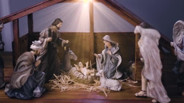 Ježíš Kristus Narození scéna s figurkami ve stabilních a světlých částicích. Ježíš Kristus se narodil v jeslích s Marií a Josefem. Vánoční scéna. Dolly shot 4k - Záběry, video