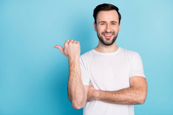 Photo of satisfied man toothy smile direct thumb empty space proposition isolated on blue color background - Foto, afbeelding
