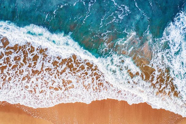 Agua turquesa con olas con fondo de playa de arena desde vista aérea. Concepto de verano soleado imagen de viaje - Foto, imagen