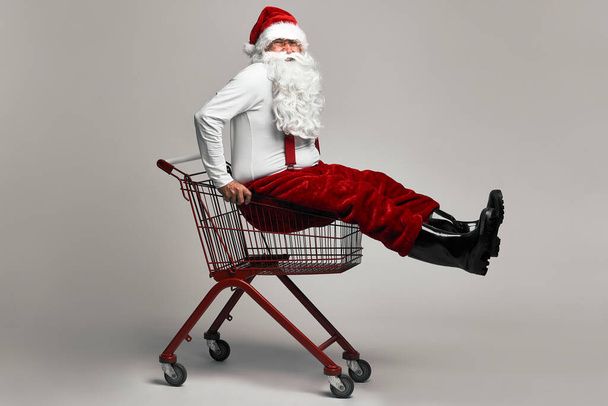 Caucasian Santa Claus sitting in shopping cart  - Photo, Image