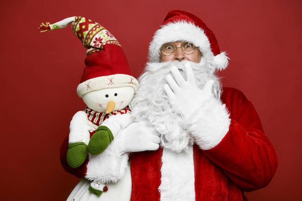 Funny caucasian Santa Claus with cute snowman  - Фото, изображение