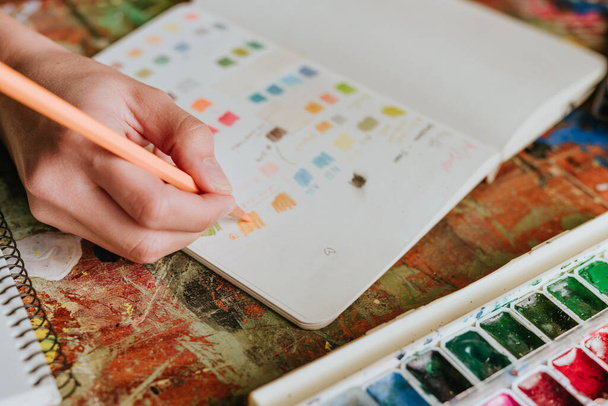 Junge Künstlerin bereitet Farbspektrum vor und wählt die richtige Farbe - Foto, Bild