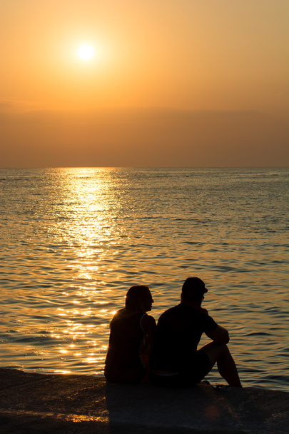 pareja joven en la playa al atardecer - Foto, Imagen