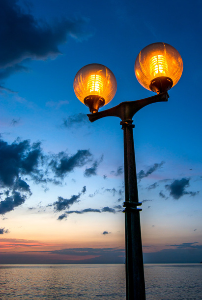 曇り夜の空と風光明媚な街灯 - 写真・画像
