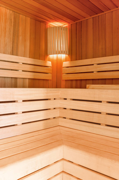 Saunaraum. Saunainnenraum aus Holz mit Kupfereimer. Badaccessoires. Finnische Sauna von kleiner Größe.  - Foto, Bild