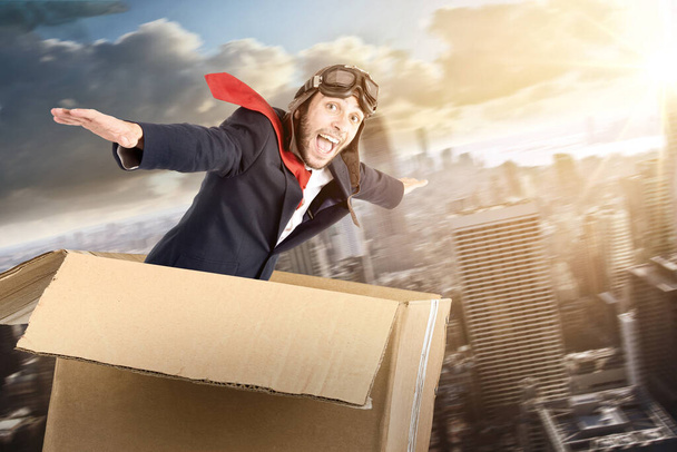 Businessman flying a carboard box over the skies - Photo, Image