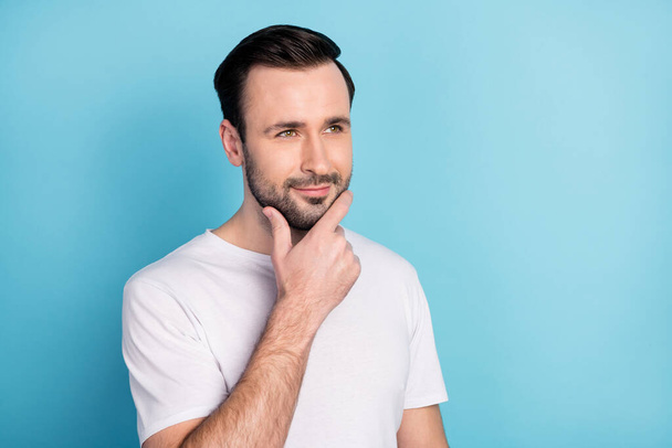 Portrait of attractive minded cheerful dreamy guy overthinking touching chin isolated over blue bright pastel color background. - Photo, Image