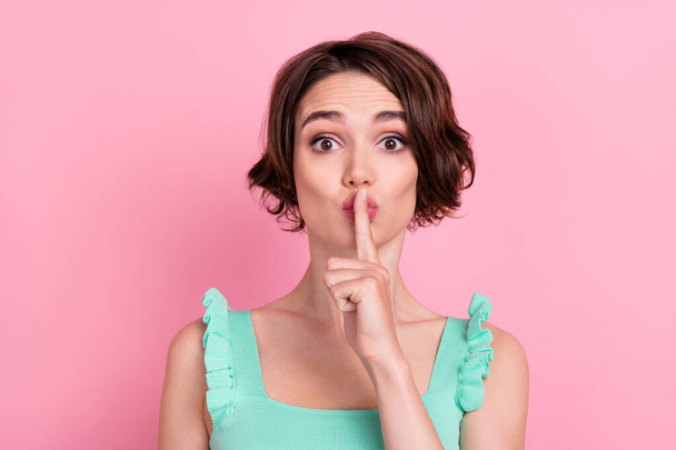 Portrait of attractive suspicious cautious girl showing shh sign isolated over pink pastel color background. - Photo, Image