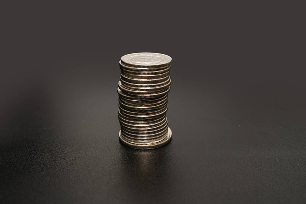 Monedas se amontonan sobre la mesa presentando planes financieros. Planes hipotecarios para el hogar y la oficina usando dinero. - Foto, imagen