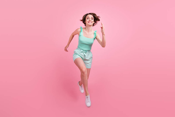 Full length body size view of attractive cheerful girl jumping running fast isolated over pink pastel color background - Foto, imagen