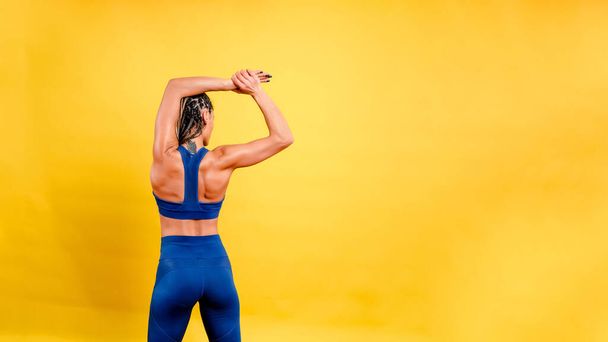 sports girl doing exercise, on a yellow background - Photo, Image