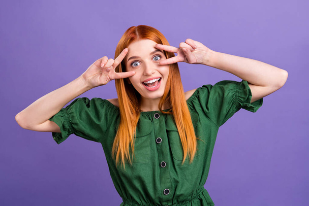 Photo of impressed red hair young lady show v-sign wear green open shoulders blouse isolated on violet color background - Valokuva, kuva