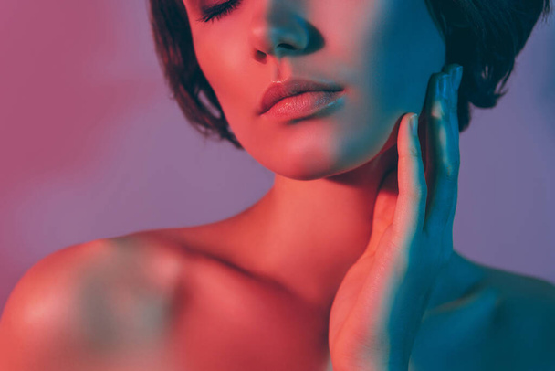 Foto cortada menina calma com ombros nus tocando pescoço rosto sonhador isolado neon cor fundo - Foto, Imagem