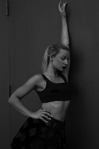 Schwarz-weißes Porträt einer blonden attraktiven Frau in einer Tanzpose. Vertikal. - Foto, Bild