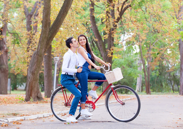 Teen couple with bike in the park in autumn time - Zdjęcie, obraz