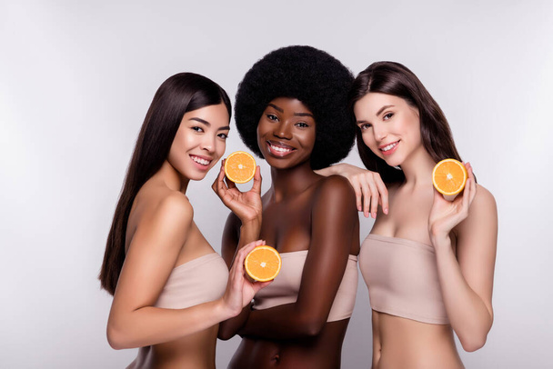 Foto tres mujer atractiva joven sonrisa positiva feliz celebrar rodajas de naranja cítricos aislados sobre fondo de color gris - Foto, Imagen