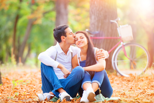 Teen couple with retro bike kissing in the park in autumn time - Valokuva, kuva