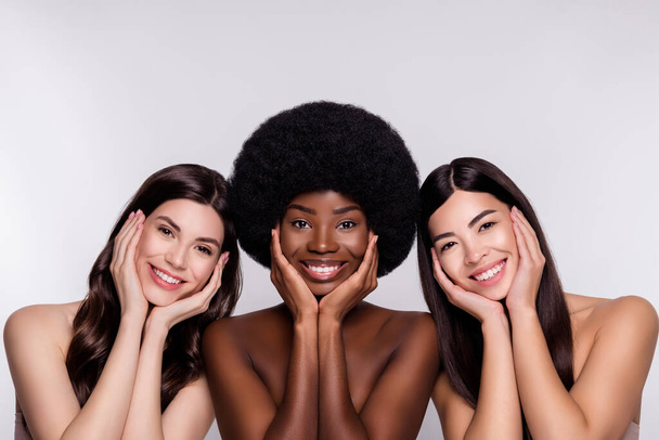 Photo of three young cheerful woman happy positive smile hands touch cheeks lifting isolated over grey color background - Foto, imagen
