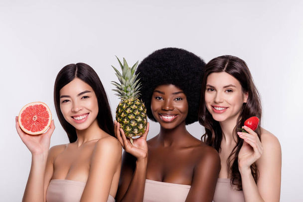 Foto van drie jonge vrouw gelukkig positieve glimlach fesh fruit huidverzorging cosmetologie geïsoleerd over grijze kleur achtergrond - Foto, afbeelding