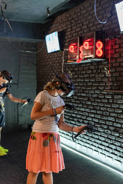 La chica en el club VR juega juegos en un casco 3d. - Foto, imagen