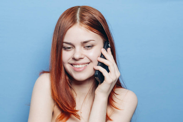 woman with red hair bare shoulders talking on the phone - Fotografie, Obrázek