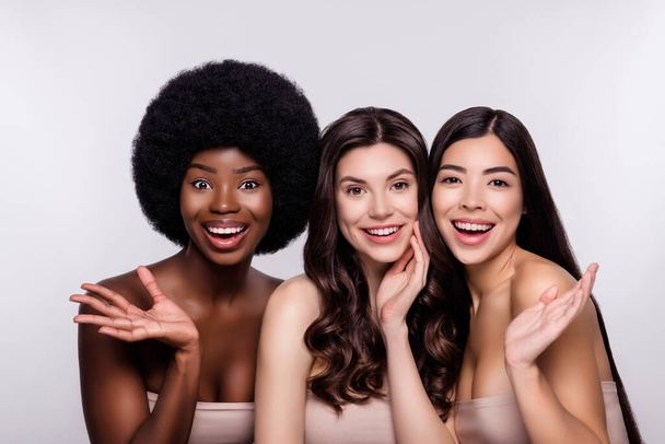 Фото трьох молодих привабливих дівчат щаслива позитивна посмішка схвильована насолоджуйтесь реакцією шкіри ізольовані сірий колір фону
 - Фото, зображення